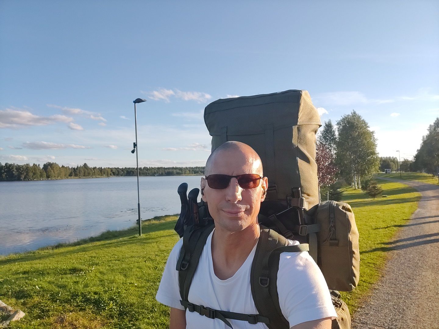 Niko standing near Kirkkolahti, with a full hiking backpack, waiting for the bus.