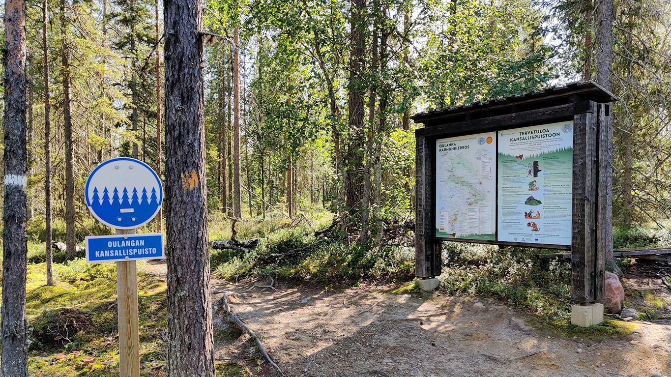 A sign and a info-board detailing the edge of and area of Oulanka national park.