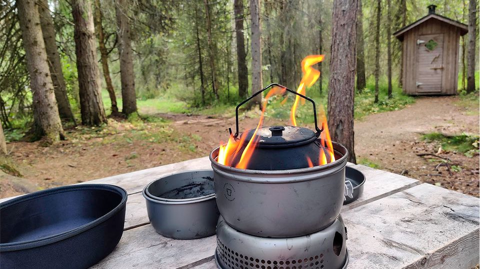 Boiling water to hydrate the dehydrated travel ration, using a camp stove.